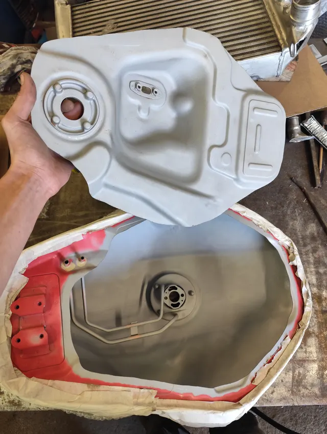Main tenant une demi-coque de réservoir nettoyée au-dessus de l'établi