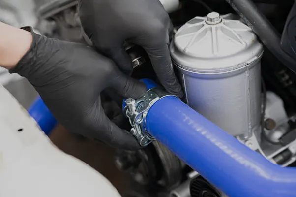 Pose d’une durite silicone bleue et de son collier sur un moteur