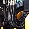 Faisceau de durites caoutchouc noires sur un engin jaune
