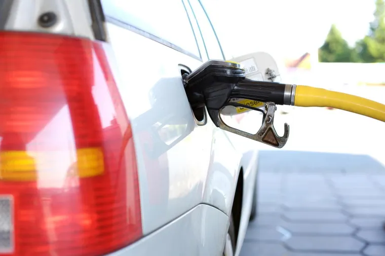 Pistolet de carburant engagé dans la goulotte de remplissage d’une voiture en station-service